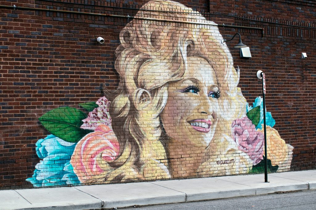 Country music legend Dolly Parton smiling in a shimmering outfit during a stage performance